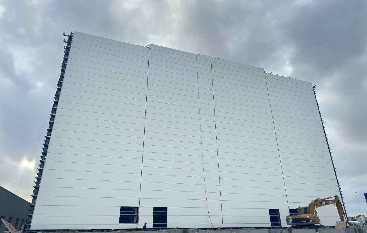 Wall cladding integrated with a rack-supported warehouse structure