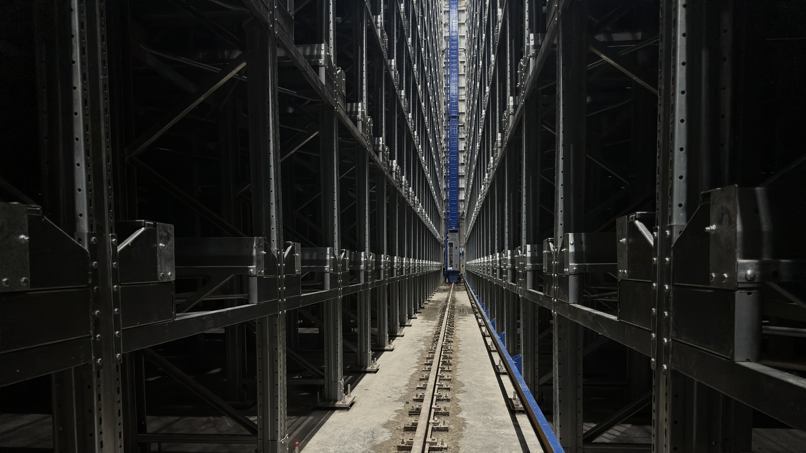 Stacker crane operating in a rack-supported ASRS warehouse